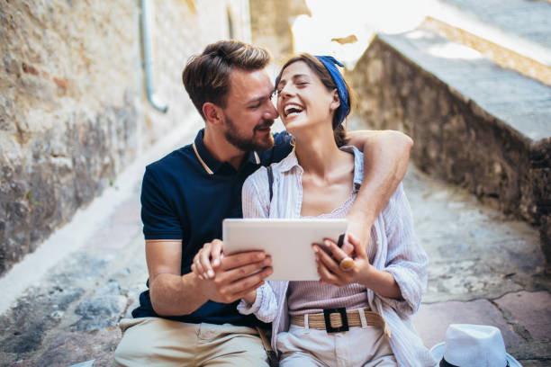 istock Romantic tourist couple sitting on stairs using digital tablet. 1176784212