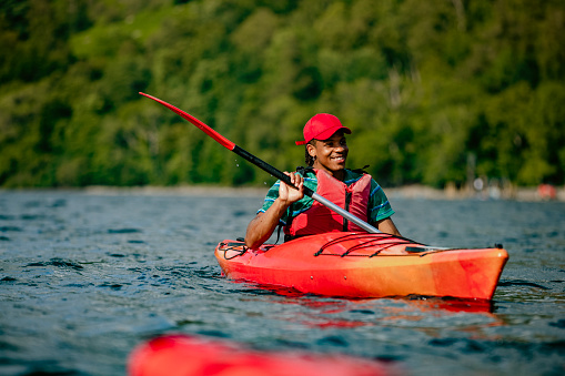 A young man having fun kayaking on Derwent Water in The Lake District