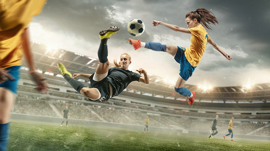 Excitement. Young female soccer or football players in sportwear kicking ball for the goal in action at the stadium. Concept of healthy lifestyle, sport, motion, movement. Collage made of 2 models.