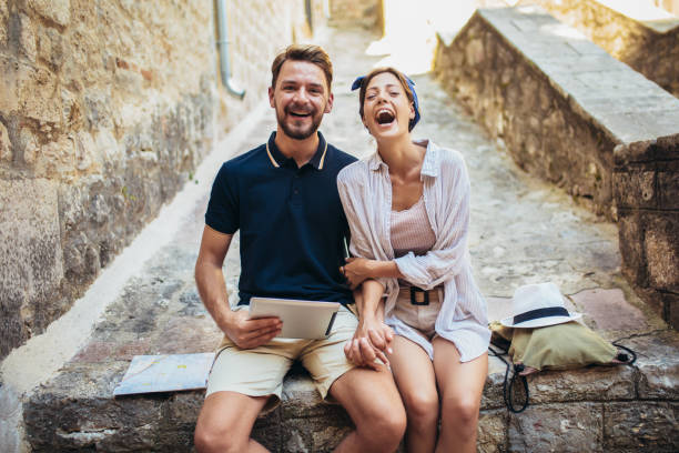 istock Romantic tourist couple sitting on stairs using digital tablet. 1176786053