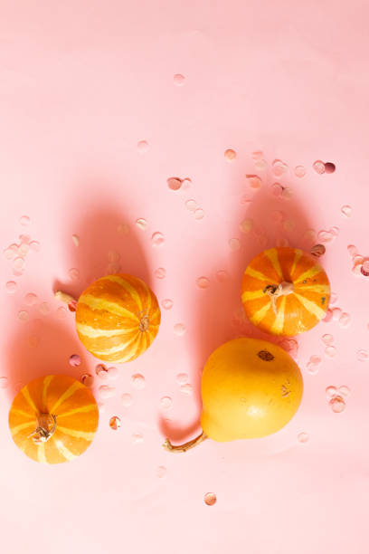 Trendy background with orange halloween pumpkin and glitter decor with copy space for text. Flat lay, top view.