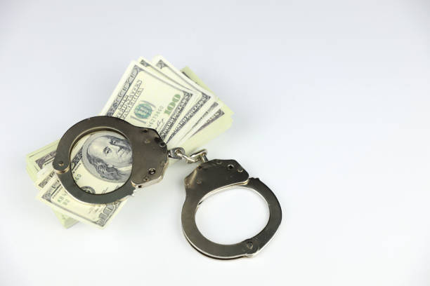 istock metal handcuff on 100 dollars banknote stacking on white background 1176792590
