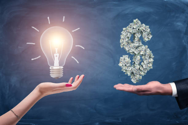 A female and a male hands holding a large bright light bulb and a dollar sign made of many money bills. A female and a male hands holding a large bright light bulb and a dollar sign made of many money bills. Money and wealth. Profitable ideas. Financial streak. giving money stock pictures, royalty-free photos & images