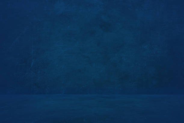 istock dark blue cement wall studio background, empty showroom to present product 1176793971