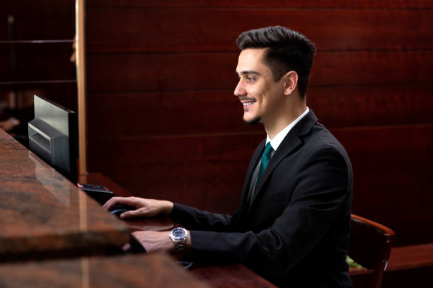 istock A smiling receptionist at his desk 1176795742