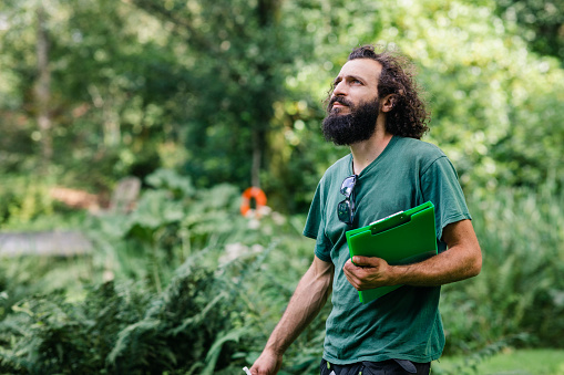Man wearing green t shirt with beard planning landscaping project