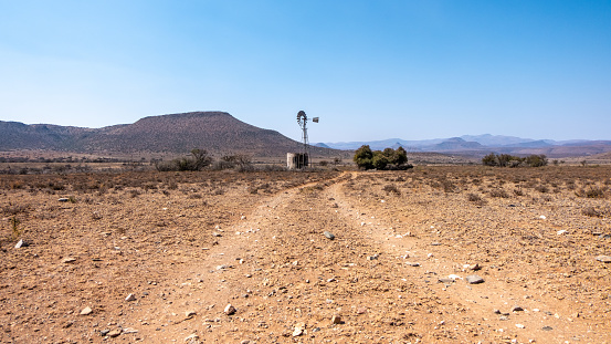 Dirt road to wind pump and water reservoir on a farm in South Africa