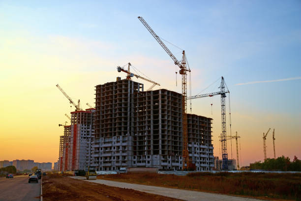 Crane and building silhouettes at blue yellow sky, sunset