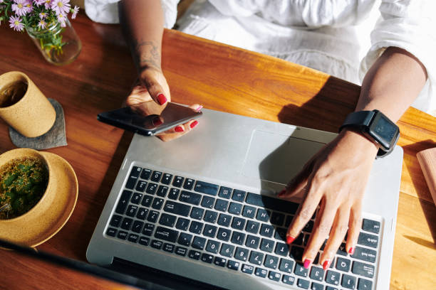 istock Woman connecting phone with laptop 1176803141