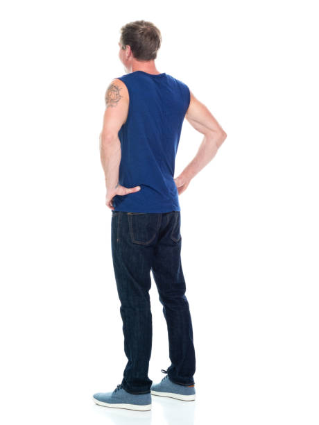 full length / rear view / back / one man only / one person of 20-29 years old adult handsome people caucasian male / young men sleeveless standing wearing tank top / jeans / pants / canvas shoe / cool attitude with hand on hip - 16330 imagens e fotografias de stock