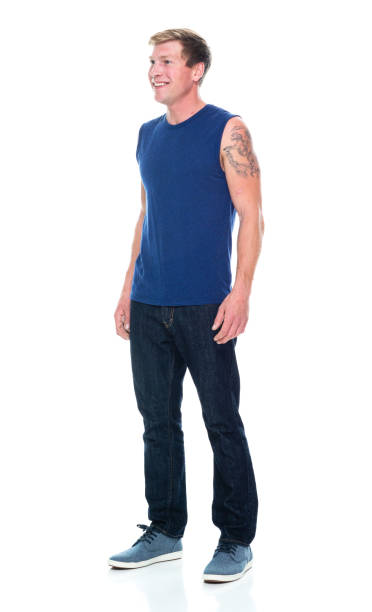 full length / side view / profile view / one man only / one person of 20-29 years old adult handsome people caucasian male / young men sleeveless standing wearing tank top / jeans / pants / canvas shoe who is smiling / happy / cheerful / laughing - 16318 imagens e fotografias de stock