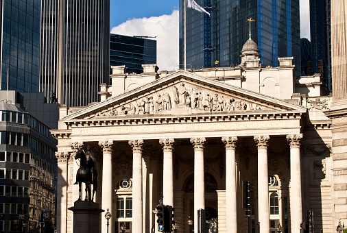 London, UK - May 21, 2019: The Royal Exchange with the modern buildings of the City of London in the background. The Exchange was opened in 1571, and currently it serves as a luxury shopping centre.