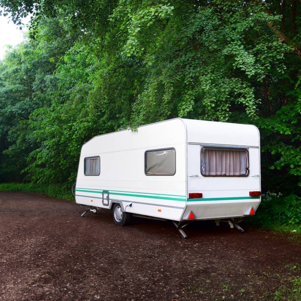 istock Caravan trailer and a car on a forest road, on a summer day 1176805727