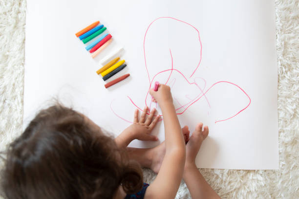 istock Little girl drawing with crayon 1176807692