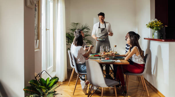 young man hosting dinner party - eating people group of people home interior imagens e fotografias de stock