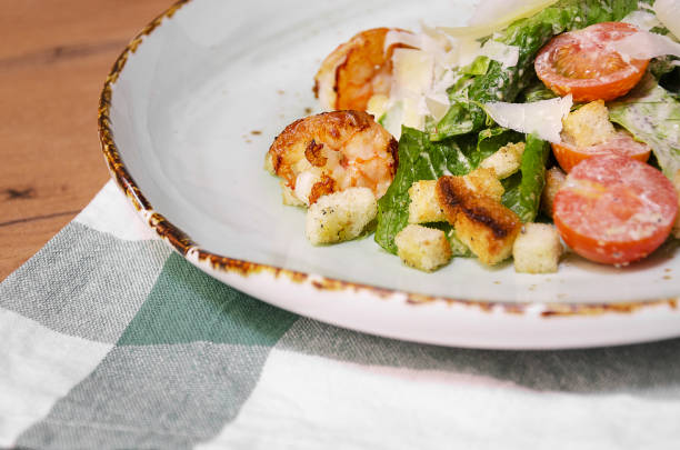 istock Shrimp Caesar salad with Parmesan cheese, croutons and lettuce 1176808315