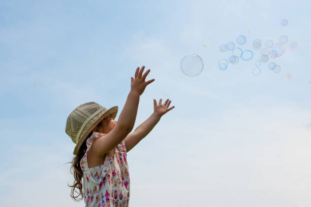 istock Toddler girl reaching for soap bubbles 1176808614