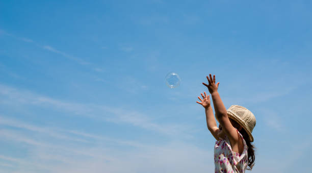 istock Toddler girl reaching for soap bubbles 1176808620