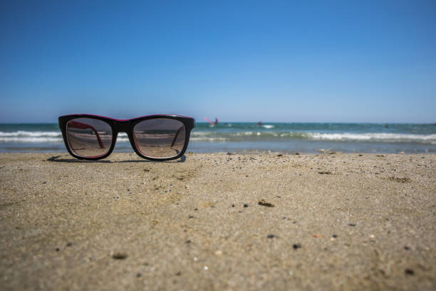 istock Sunglasses on the sand by the sea 1176810013