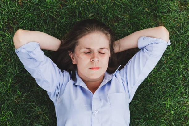 istock Woman sleeping outdoors on green grass 1176810597