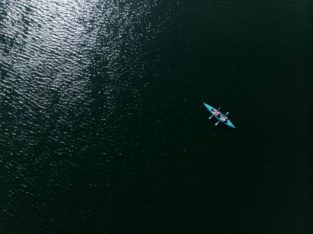 un drone che spara a un kayak che galleggia nell'acqua. - water sport lake canoe canoeing foto e immagini stock