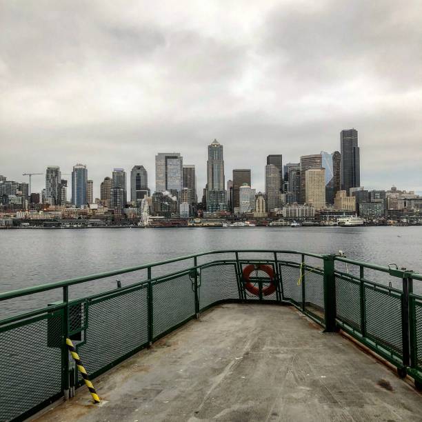 istock Seattle skyline under a cloudy sky with a view from a ferry boat on Puget Sound 1176815115