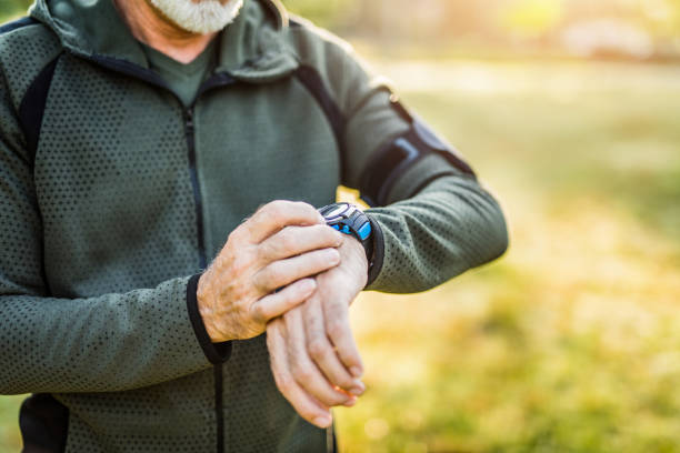 istock Senior man using digital watch outdoors. 1176815343