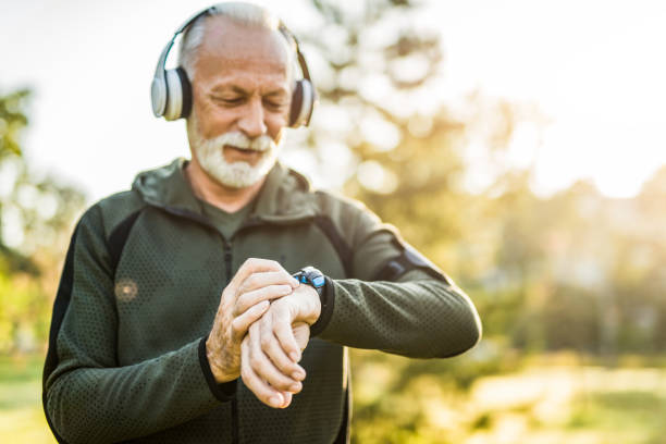 istock Senior man using digital watch outdoors. 1176815395