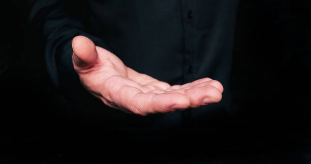 istock Open male hand on dark background 1176816020