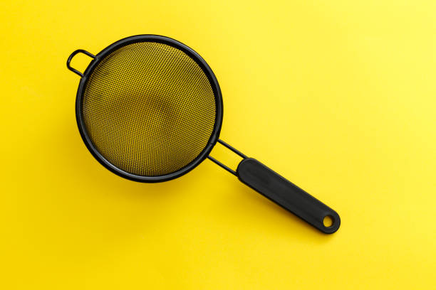 aluminum kitchen colander with plastic yellow handle isolated on white background.