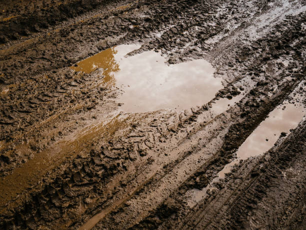 mud and slush brown. deep, impenetrable mud. danger of getting stuck - dirt road textured dirt mud imagens e fotografias de stock