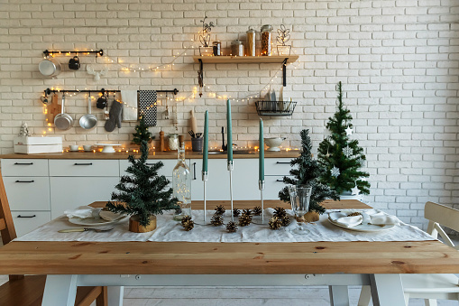 Año Nuevo y Navidad. Cocina festiva en decoraciones navideñas. Velas, ramas de abeto, soportes de madera, colocación de mesa. photo