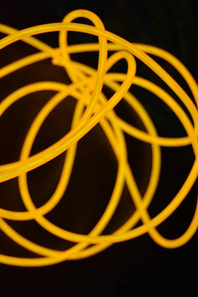 istock Bright orange luminous wire, twisted light wire, cable. Different shapes and images of lectroluminescent wires with different twists, juicy el wire. 1176823725
