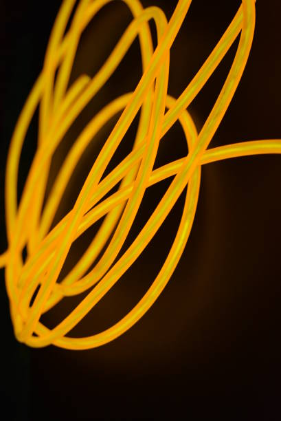istock Bright orange luminous wire, twisted light wire, cable. Different shapes and images of lectroluminescent wires with different twists, juicy el wire. 1176823738