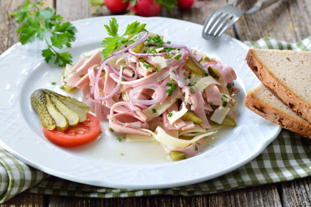 Hearty Bavarian sausage salad with cheese strips, pickles and rustic farmhouse bread