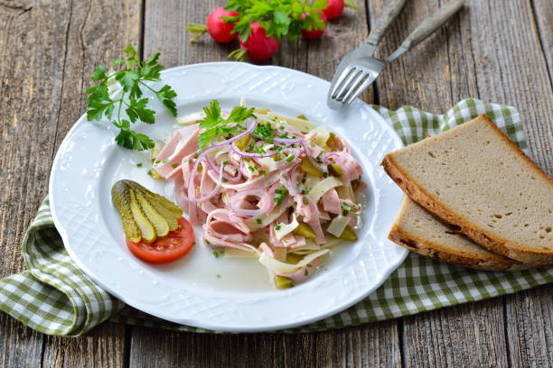 Hearty Bavarian sausage salad with cheese strips, pickles and rustic farmhouse bread