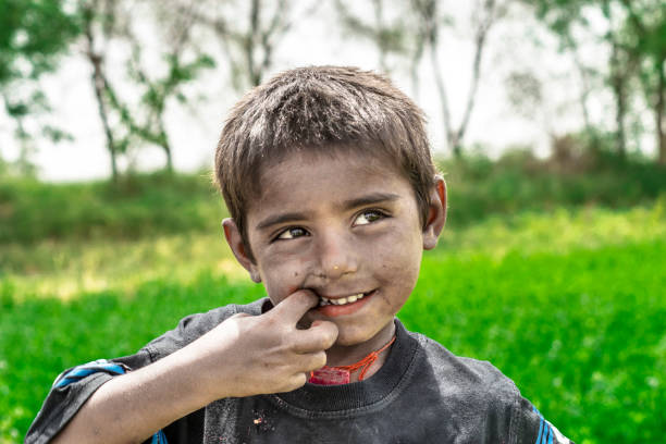 istock poor villager smiling boy in a farm 1176825337