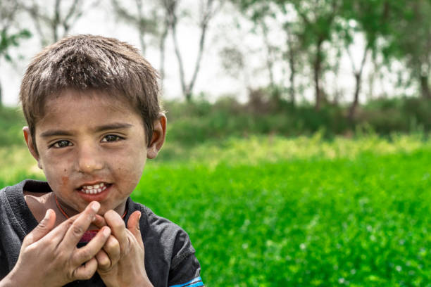 istock poor villager smiling boy in a farm 1176825524