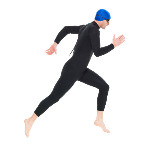 full length / one man only / one person / side view / profile view of 30-39 years old handsome people caucasian male / mid adult men / mid adult triathlete doing triathlon / swimming / running / exercising in front of white background - swimming male isolated swimming goggles imagens e fotografias de stock