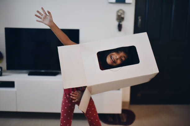 istock Girl wearing box over head and peeking through it 1176827049
