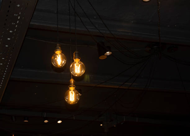 istock Lighting decor. Hanging Light Bulb in the dark room with copy space. 1176827651