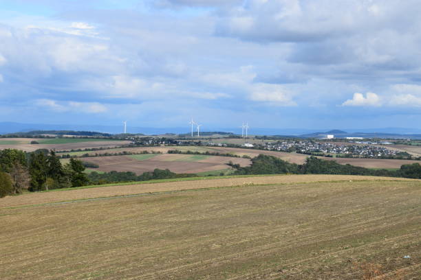 istock wide landscape with plowed fields and wind turbines 1176827676