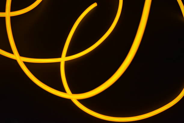 istock Bright orange luminous wire, twisted light wire, cable. Different shapes and images of lectroluminescent wires with different twists, juicy el wire. 1176830363