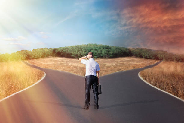istock A businessman faces a choice in front of a forked road. Decision strategy. Concept of uncertainty 1176832427