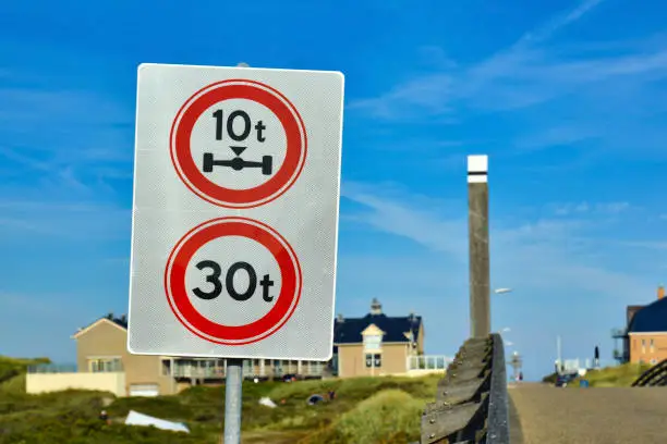 Photo of Double traffic sign with sign prohibiting throroughfare of vehicles with a weight over 30 metric tons and with an axle weight heavier than 10 metric tons