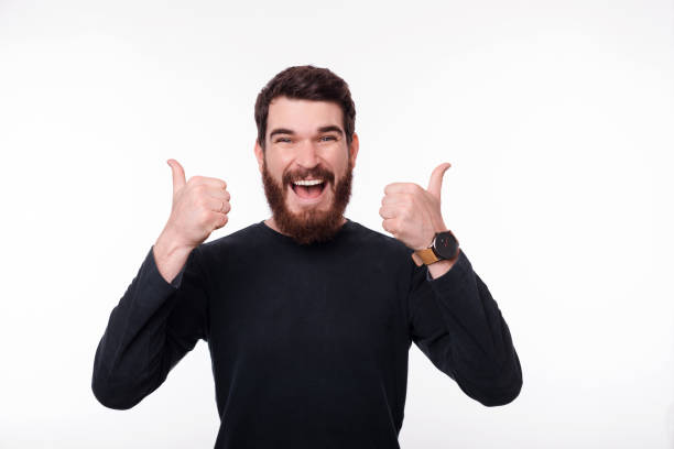 istock Smiling young man showing thumbs up over white background 1176840789
