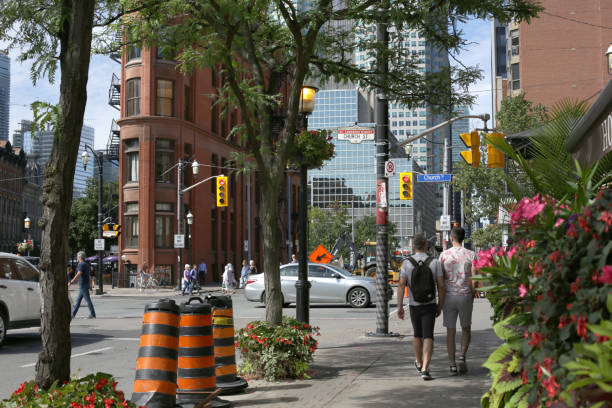 St. Lawrence Neighbourhood, Toronto, Canada Toronto, Canada - August 22, 2019: Summer morning in the popular St. Lawrence neighbourhood. The historic Gooderham Building or Flatiron Building stands on a wedge-shaped block bounded by Wellington Street East, Front Street East and Church Street. Background shows the modern buildings of the Financial District downtown. flatiron building toronto stock pictures, royalty-free photos & images