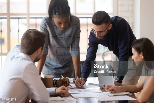 Focused Multiracial Corporate Business Team People Brainstorm On Paperwork Stock Photo - Download Image Now