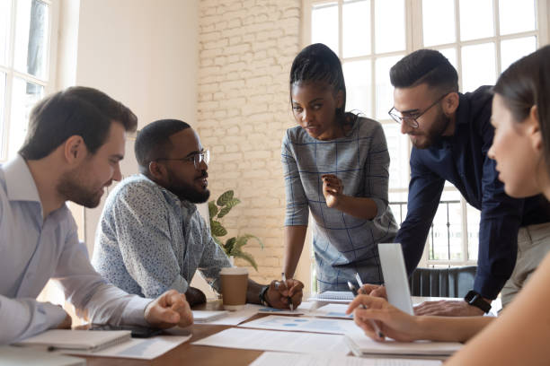 istock Serious multiracial corporate business team discuss paperwork at group briefing 1176842724