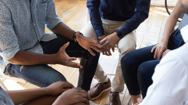 African man counselor speak at group counseling therapy session African man counselor therapist coach psychologist speak at group counseling therapy session concept encourage support patients in addiction talk share problem sit in circle in rehab, close up view small group of people stock pictures, royalty-free photos & images